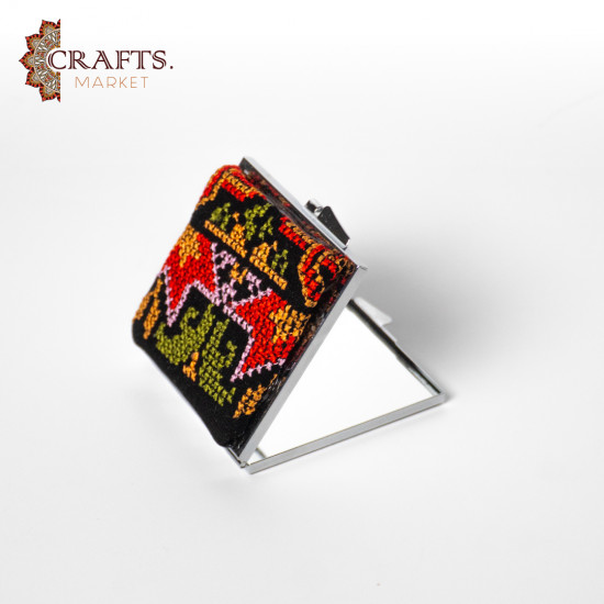 A mirror decorated with hand embroidery A mirror decorated with hand embroidery