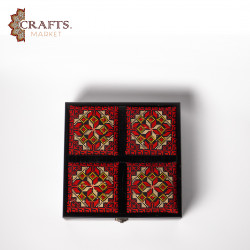 A handmade wooden gift box with a multicolored embroidered design