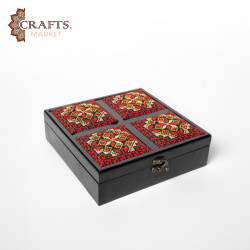 A handmade wooden gift box with a multicolored embroidered design