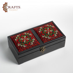 A handmade wooden gift box with a multicolored embroidered design