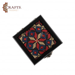 A handmade wooden gift box with a multicolored embroidered design