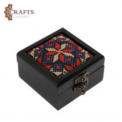 A handmade wooden gift box with a multicolored embroidered design